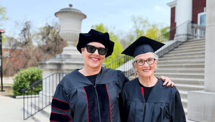 Mother and daugther, Susan and Ramie, smile in the UofL caps and gowns on campus