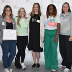 A group stands together holding an award.