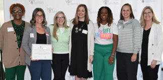 A group stands together holding an award.