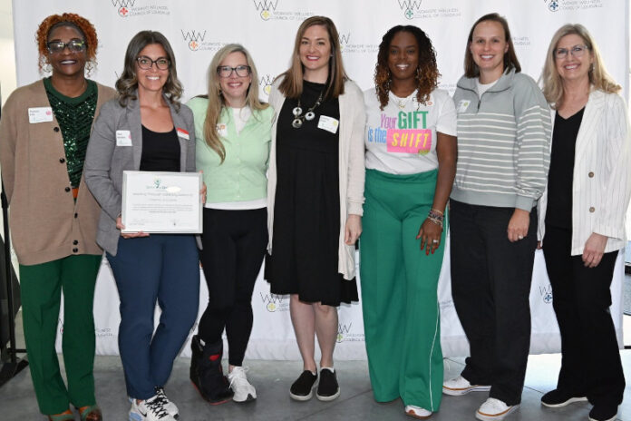A group stands together holding an award.