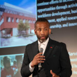 Man holding a microphone giving a talk.