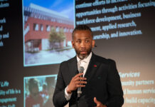 Man holding a microphone giving a talk.