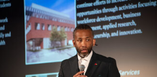 Man holding a microphone giving a talk.