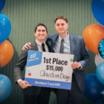 UofL student team wins intercollegiate pitch competition Two male students hold a sign announcing their $15,000 win in a student competition