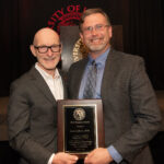 University of Louisville President Gerry Bradley (left) presents Aaron Calhoun with the 2026 UofL Trustees Award.