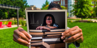 A student holds a copy of UofL Magazine