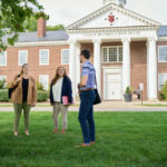 Cardinal Intelligence innovator advances law education and workforce applications Students talking on the lawn outside the Brandeis School of Law.