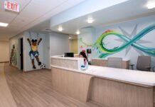 Reception counter with colorful graphic murals, one includes a young child kicking a soccer ball