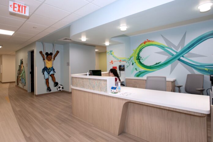 Pediatric NeuroRecovery Front Lobby Reception counter with colorful graphic murals, one includes a young child kicking a soccer ball
