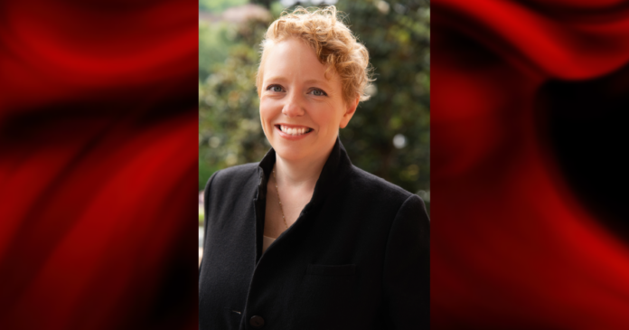 Jess Vodden Woman in black jacket set within a red template frame