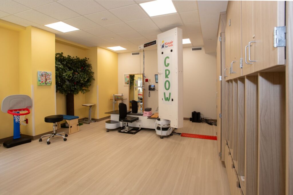 Treadmill in spacious room that includes dimensional artificial tree on wall.