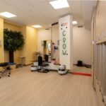Treadmill in spacious room that includes dimensional artificial tree on wall.