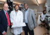 Three men standing in a medical research laboratory.
