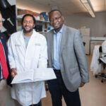 New federal designation elevates UofL physician-scientist training program Three men standing in a medical research laboratory.