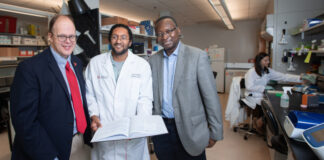New federal designation elevates UofL physician-scientist training program Three men standing in a medical research laboratory.