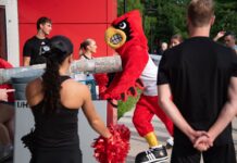 UofL welcomes Class of 2030 Louie the Cardinal bird mascot helps push items in a large bin into a residence hall.