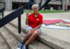 Why thousands of incoming students are saying #UofLYes Woman wearing red shirt sitting on the steps of the Health Sciences Center courtyard.