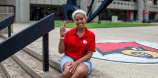 Why thousands of incoming students are saying #UofLYes Woman wearing red shirt sitting on the steps of the Health Sciences Center courtyard.