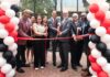 Members of the Louisville community cut a ribbon in front of the Bingham Humanities Building.