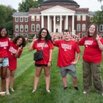 What’s new this fall, Cards? Students in red shirts stand in front of Grawemeyer Hall