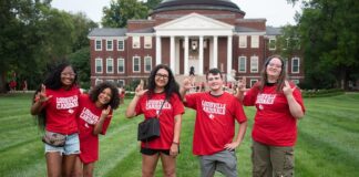 What’s new this fall, Cards? Students in red shirts stand in front of Grawemeyer Hall