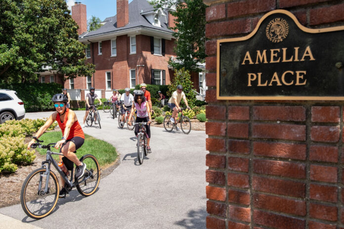 Provost and Cardinals bike out of Amelia Place's drive way/
