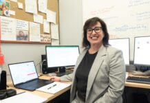 Postdocs find purpose and opportunity at UofL Smiling woman seated at desk surrounded by four computers
