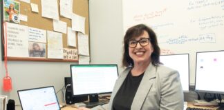 Postdocs find purpose and opportunity at UofL Smiling woman seated at desk surrounded by four computers